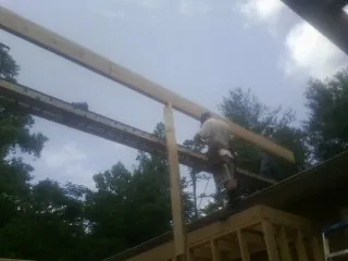 Carpenter setting a ridge beam over a new addition frame — Ice Dam Removal by Roofing Brothers in Stoughton